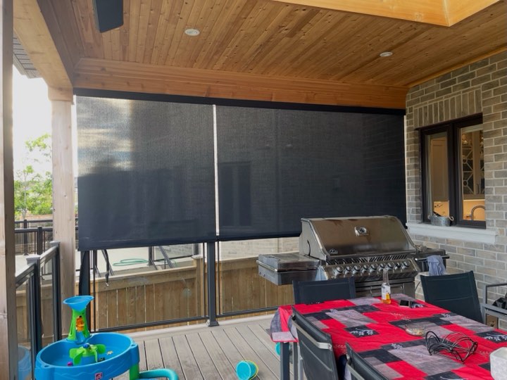 Outdoor sunscreen roller shades on a covered patio