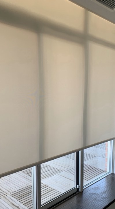 Sheer roller shade lowered on a tall window