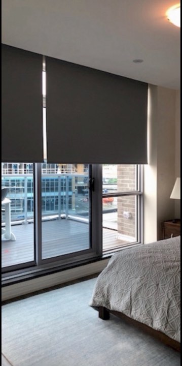 Dark roller shade in a condo bedroom