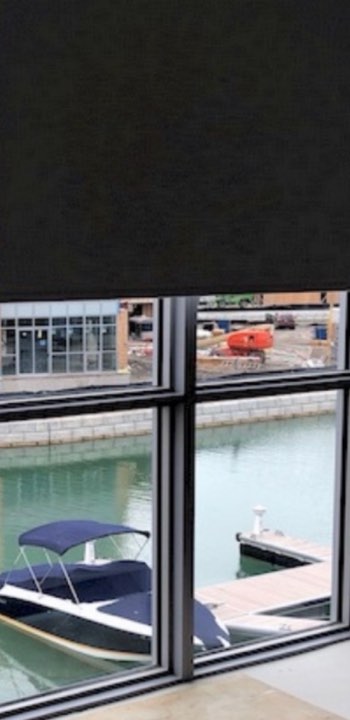 Dark roller shade over a waterfront view