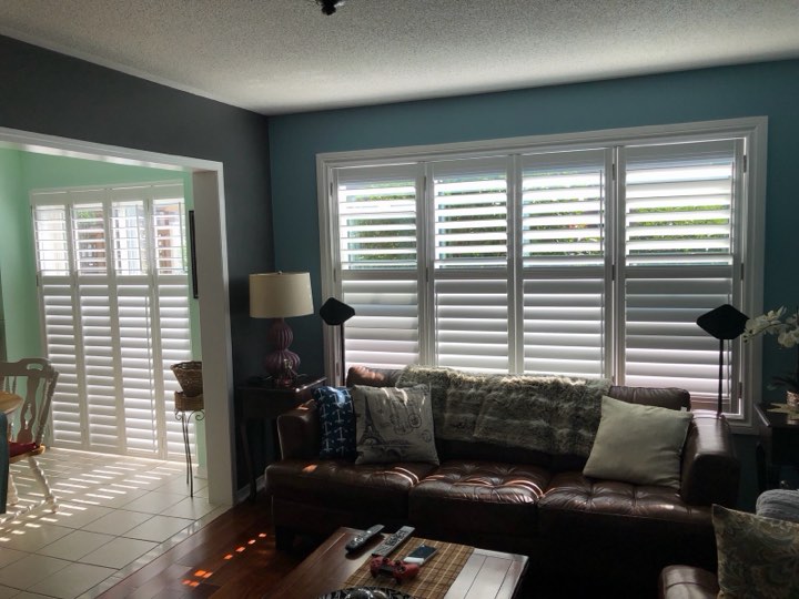 Living room with white wood shutters on two walls