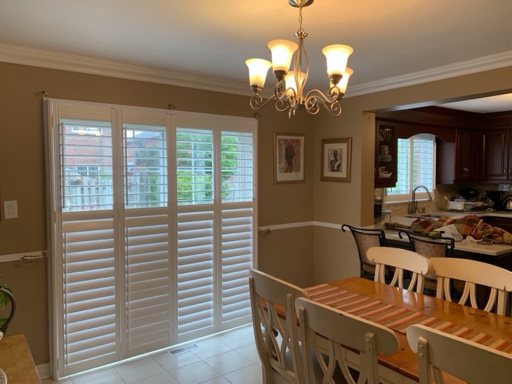 White wood shutters on a dining room patio door
