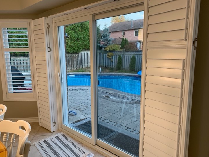 White shutters opened beside a patio door