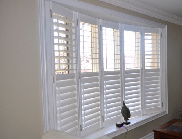 White shutters across a wide living room window