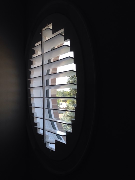 White shutters fitted to an oval window
