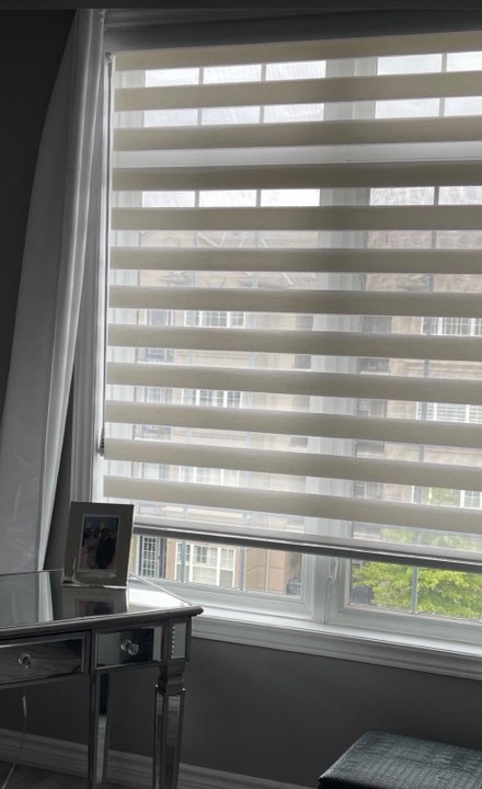 White zebra shade on a tall bedroom window