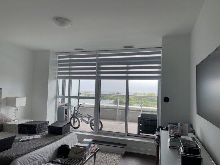Zebra shades on a condo window with a lake view
